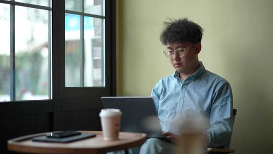 年轻人在咖啡厅使用笔记本电脑办公