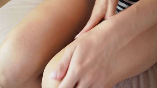 女性正在为大腿涂抹护肤品
