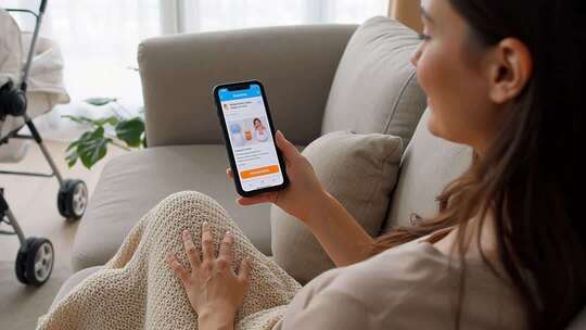 女子居家沙发上使用智能手机