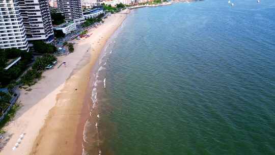 海滨城市高楼边的沙滩和海水景象