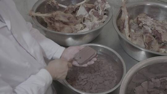 羊汤制作厨师在手掌中切割羊血豆腐中景LOG
