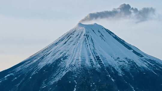 白雪覆盖的火山山顶烟雾缭绕的景象