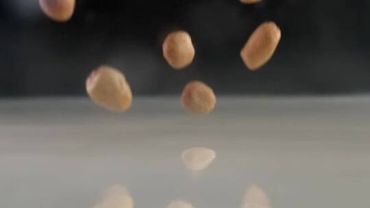 慢镜头拍摄有机花生米落入牛奶创意视频
