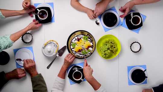 人们在白色餐桌上一起吃甜点和喝茶视频素材模板下载