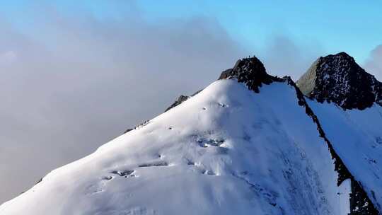 航拍攀登横断山脉乌库楚雪山山脊上的登山者