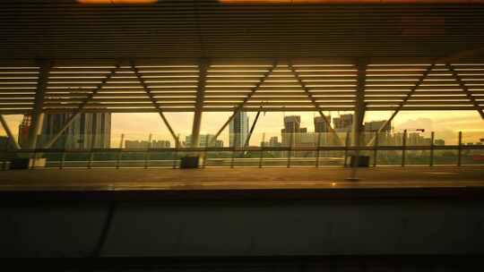 高铁飞驰经过站台窗外城市夕阳