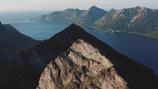 阳光明媚的一天，人们在海边攀登落基山脉