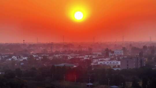 航拍平原夕阳落日房屋风力发电晚霞鸟类