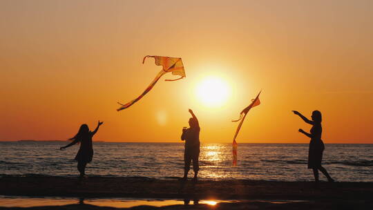 黄昏时分一家人在海边放风筝