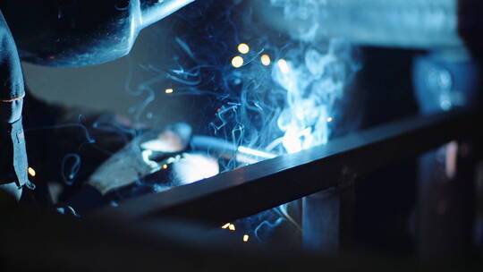 工人用工业焊机焊接钢结构激起火花