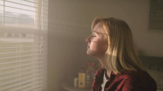阳光透过窗户洒在女人的脸上视频素材模板下载