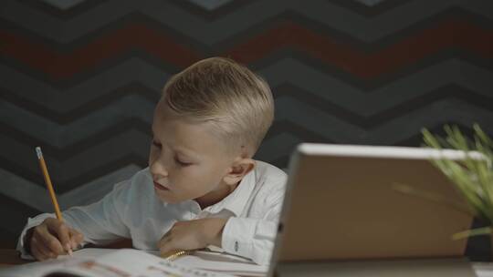 坐在桌边做作业的男孩视频素材模板下载