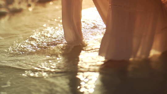 身穿白裙子在沙滩散步的年轻女性