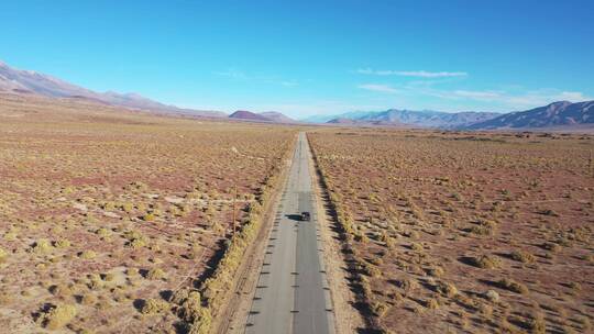 航拍汽车在欧文斯山谷沙漠公路上行驶
