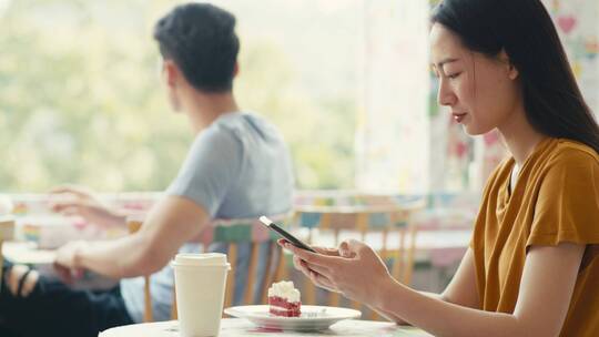 女人坐在咖啡馆看手机视频素材模板下载