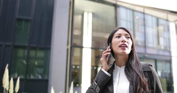 在建筑物附近打电话的女人