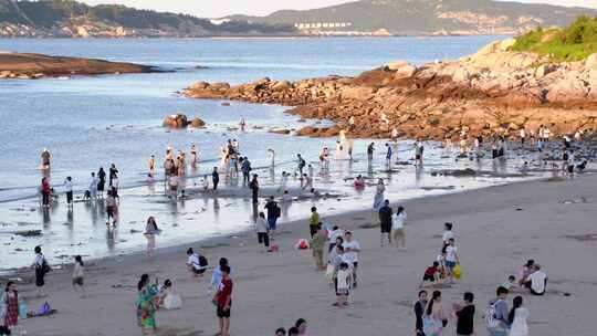 东山岛海边沙滩上人们游玩的热闹场景