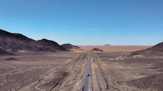 航拍西部无人区公路上零星行驶的汽车