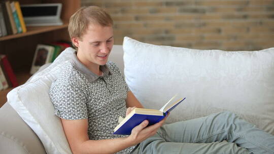 在沙发上看书微笑的男人