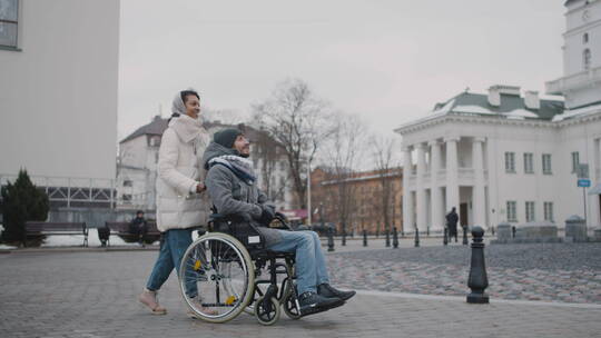 女人推着她的残疾朋友散步
