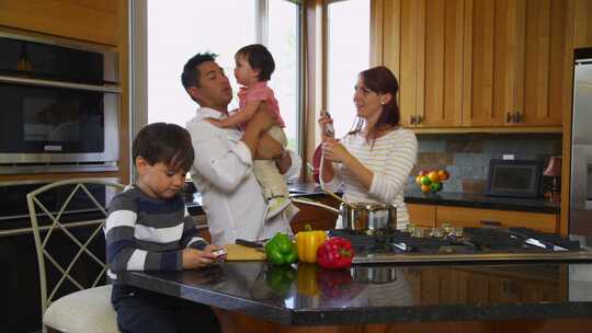 夫妇和他们的孩子在厨房做饭