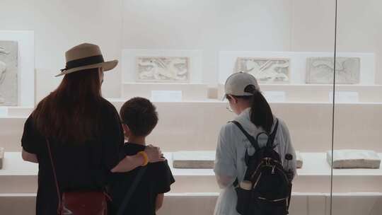 家长带着孩子在博物馆参观文物