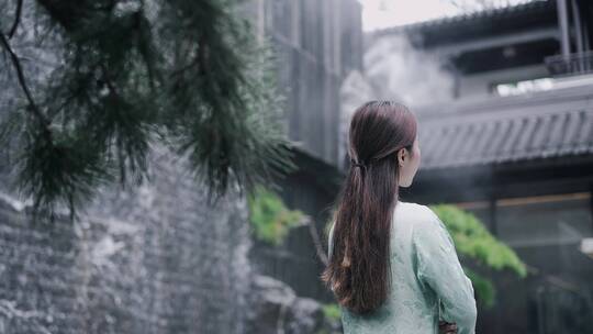 汉服年轻女子在水景墙边看着眼前的中式合院
