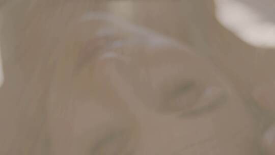 年轻女子躺在床上看着镜头