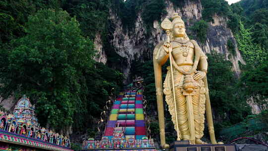穆鲁甘雕像，背景是通往巴图洞穴的彩色楼梯