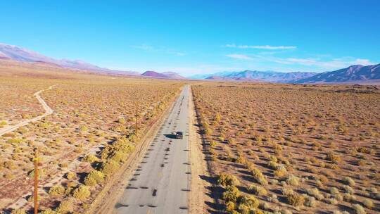 航拍一辆汽车行驶在沙漠地区的公路上
