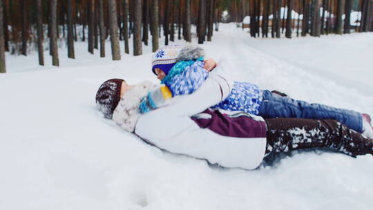 妈妈和女儿躺在雪地里玩耍
