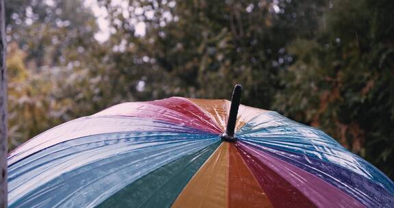 雨天雨水拍打在彩色雨伞上