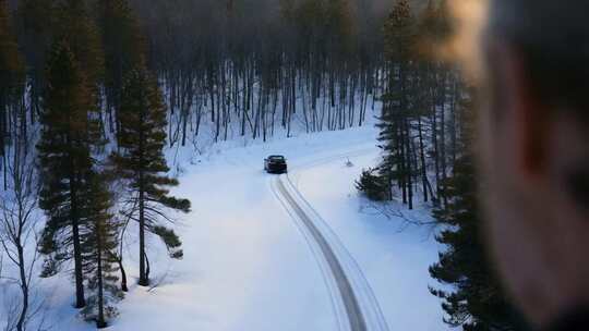 雪林中小路一辆汽车行驶而过