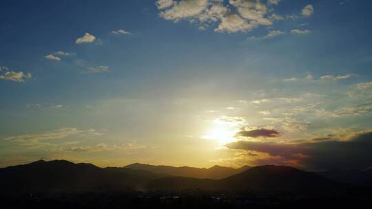 傍晚天空夕阳山日落延时黄昏山峰山脉阳光云