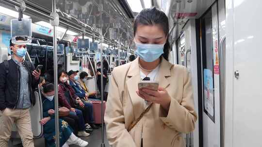 地铁上玩手机通勤上下班女人白领