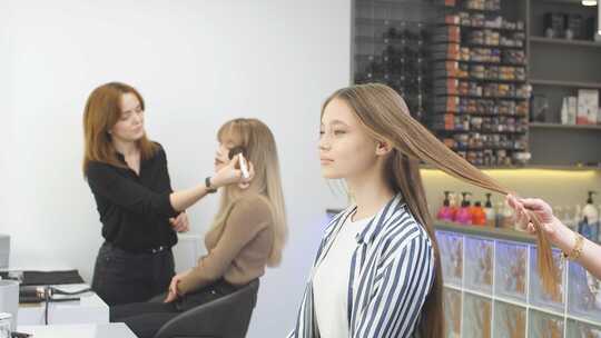 理发师为女孩做头发护理高清在线视频素材下载