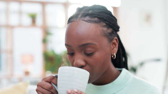 黑人妇女，在家休息时微笑着喝咖啡，放松周
