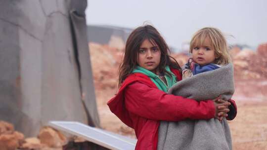 难民小女孩抱着妹妹无助等待