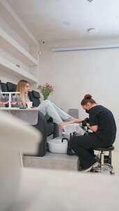 女美容师在水疗中心为客户做足部护理