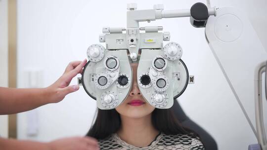 男验光师用先进仪器检查校准女顾客的视力