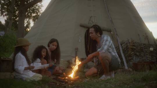 爸爸和女儿在露营地上生火