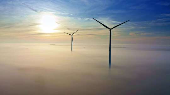 秋季日出时雾上的风力涡轮机