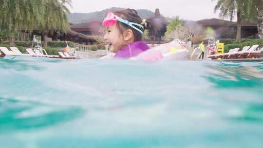 小女孩快乐的在酒店游泳池玩耍戏水视频素材模板下载
