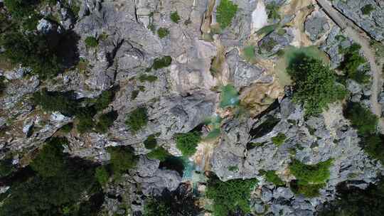 瀑布穿过岩石沟壑涌入峡谷空中的绿松石水池