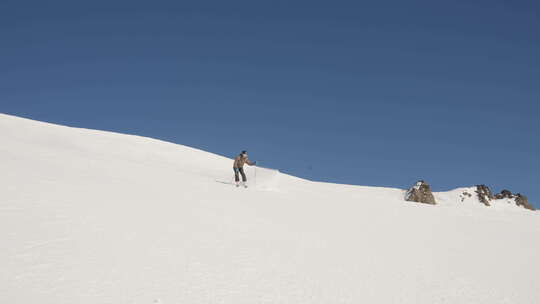 滑雪者在晴朗天空下的山上滑雪