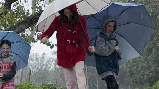 孩子们拿着雨伞在雨中玩耍