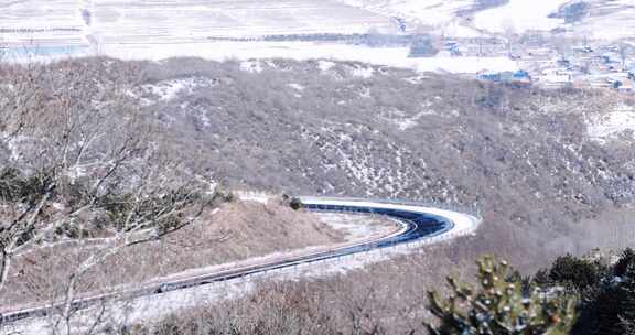 冬天大雪过后的蜿蜒山路汽车驶过