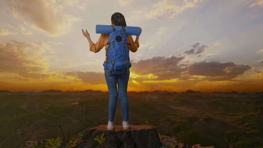 一名女性徒步旅行者在山顶张开双臂的全身后