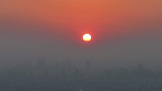 城市上空的火红色的太阳落日