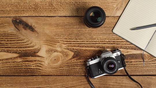 从桌子上拿起单反相机的人